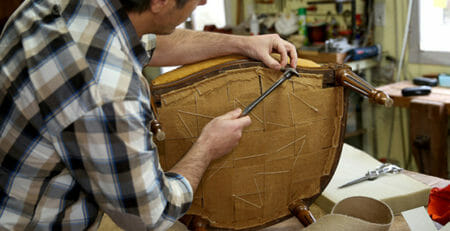 A man upholstering a chair